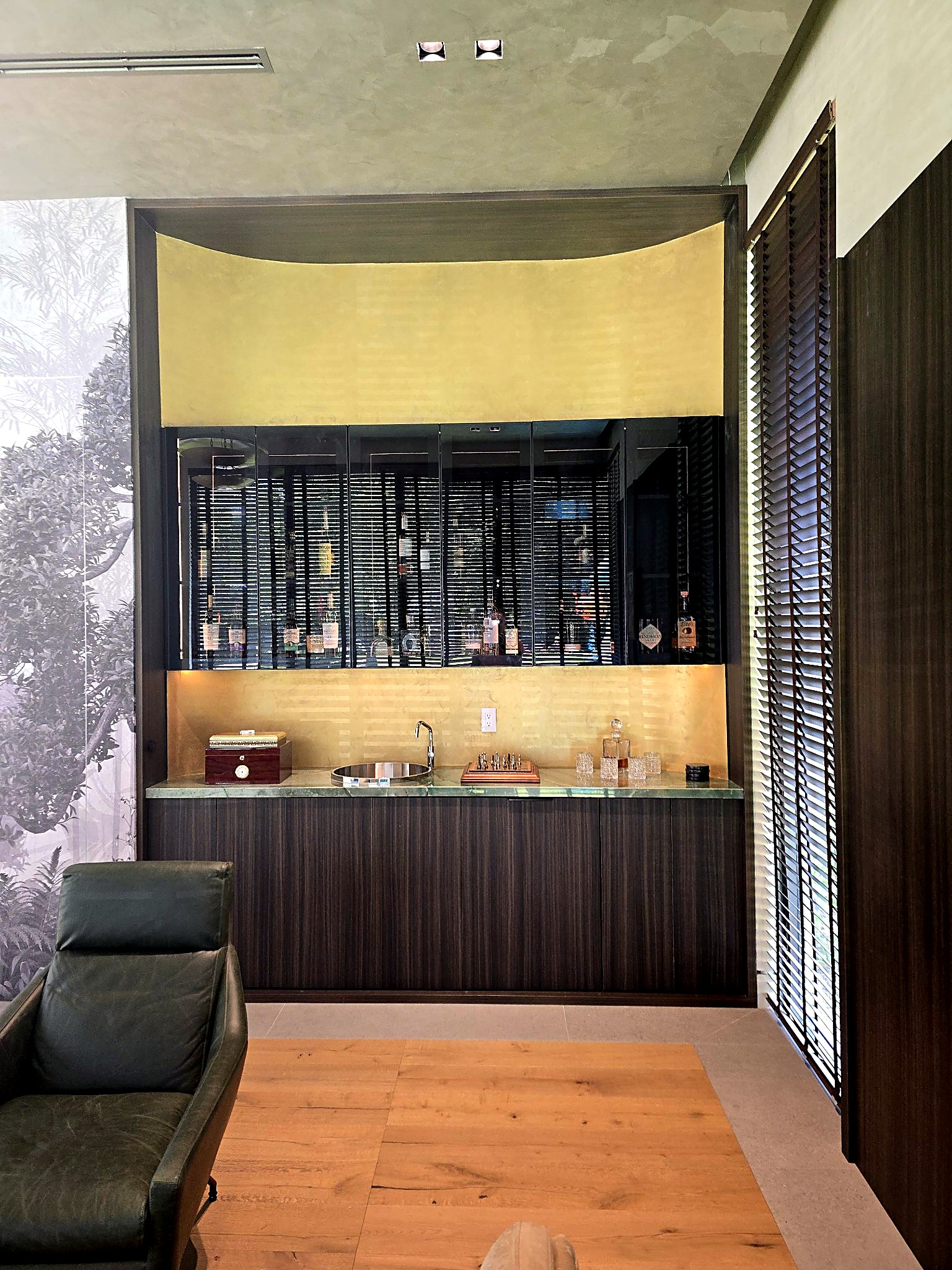 Lounge bar wrapped in a luminous hand-applied gold metallic plaster finish