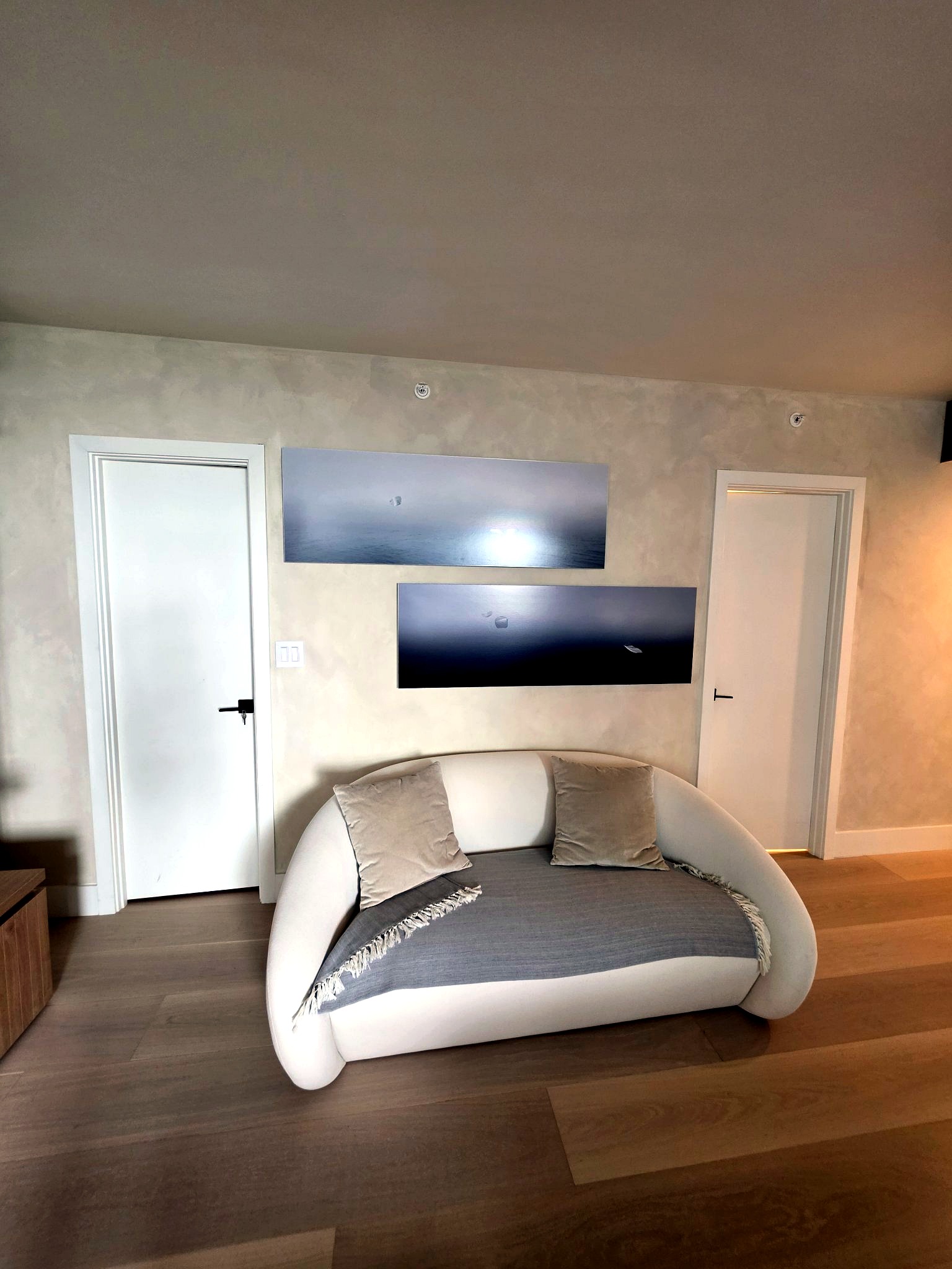 Curved sofa against a hand-applied limewash wall in a Bal Harbour residence living room