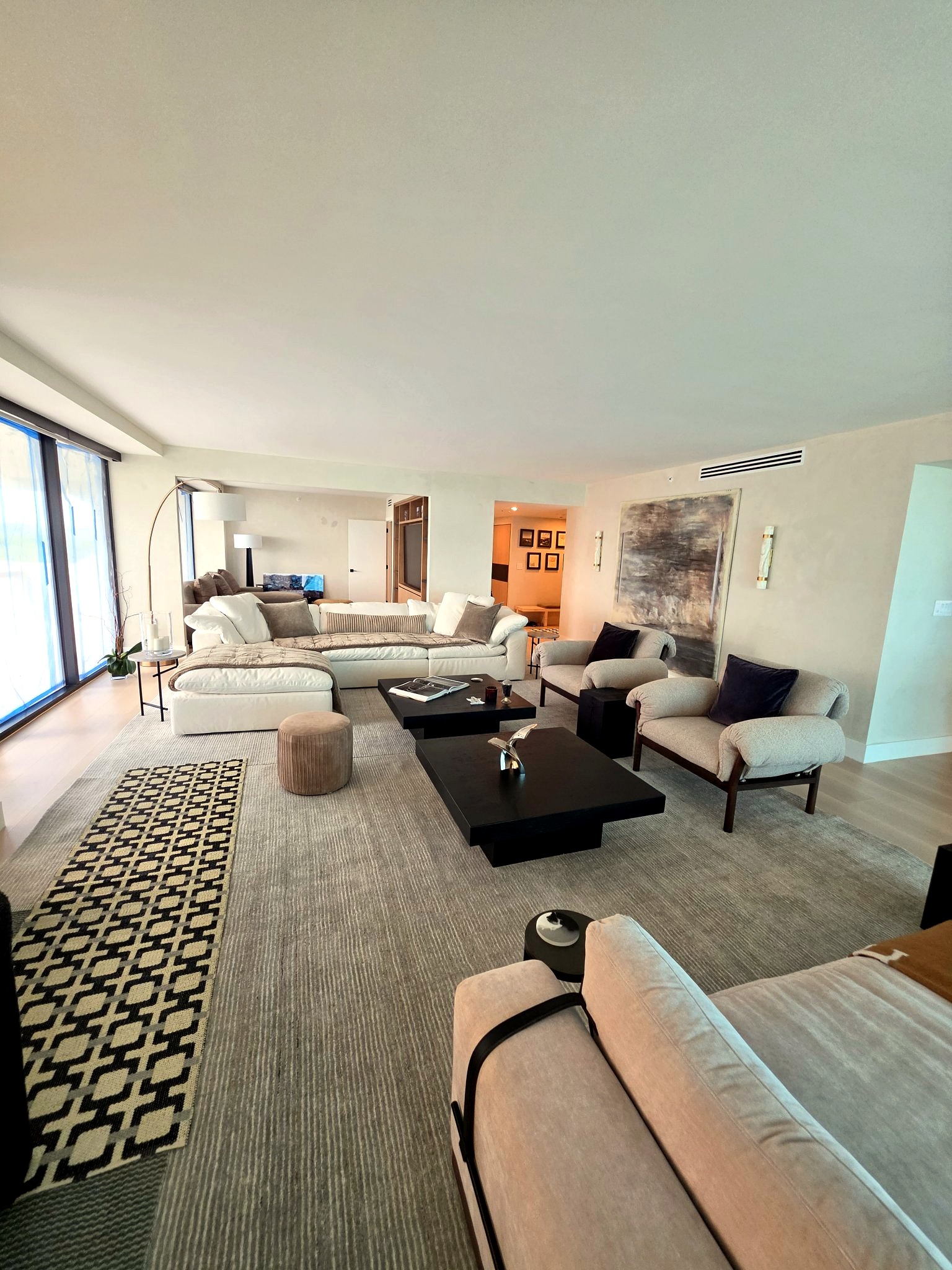 Open-plan living room with floor-to-ceiling windows and softly layered hand-applied limewash walls in a Bal Harbour residence