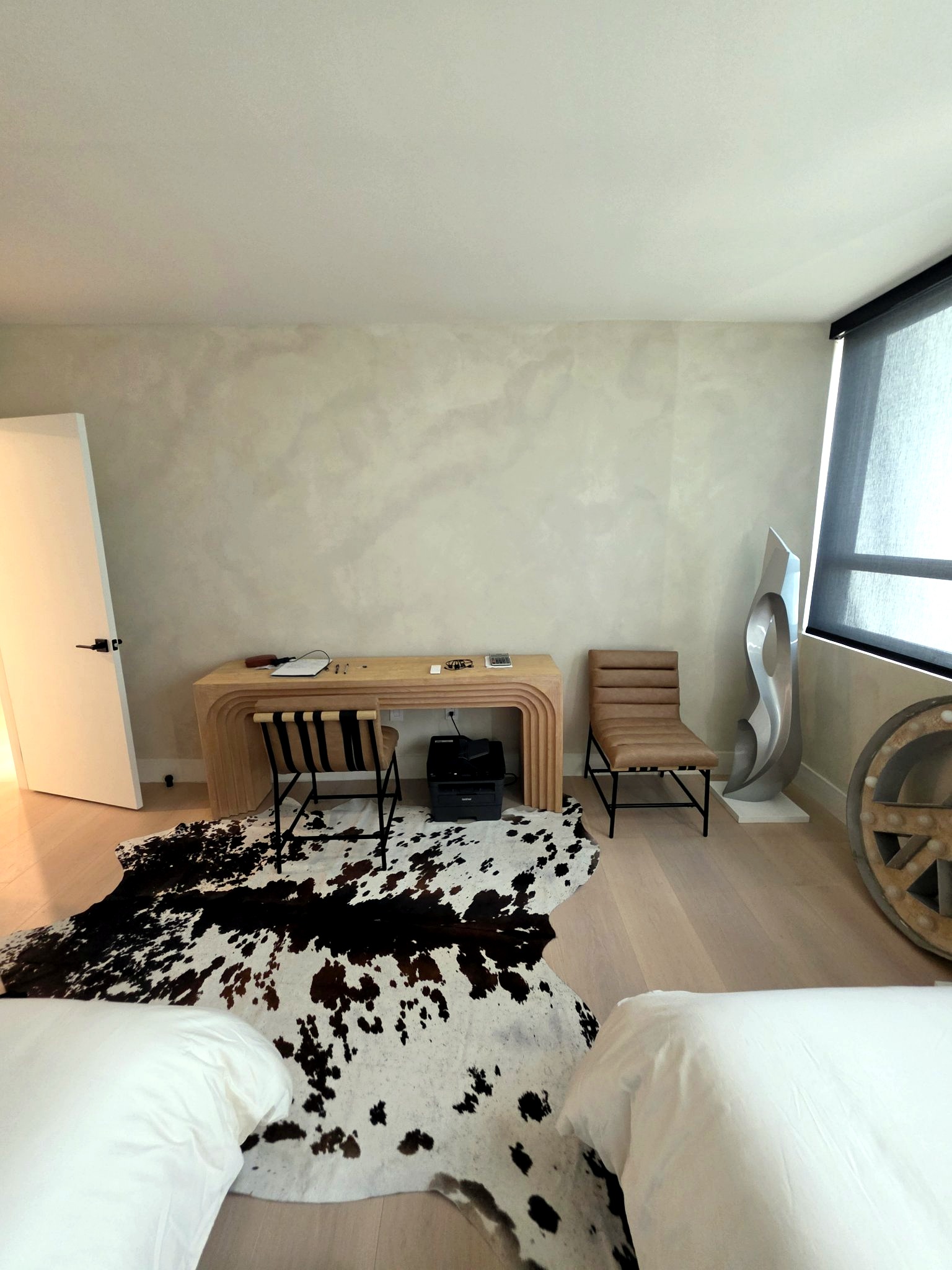 Second bedroom with twin beds and a hand-applied limewash feature wall in a Bal Harbour residence