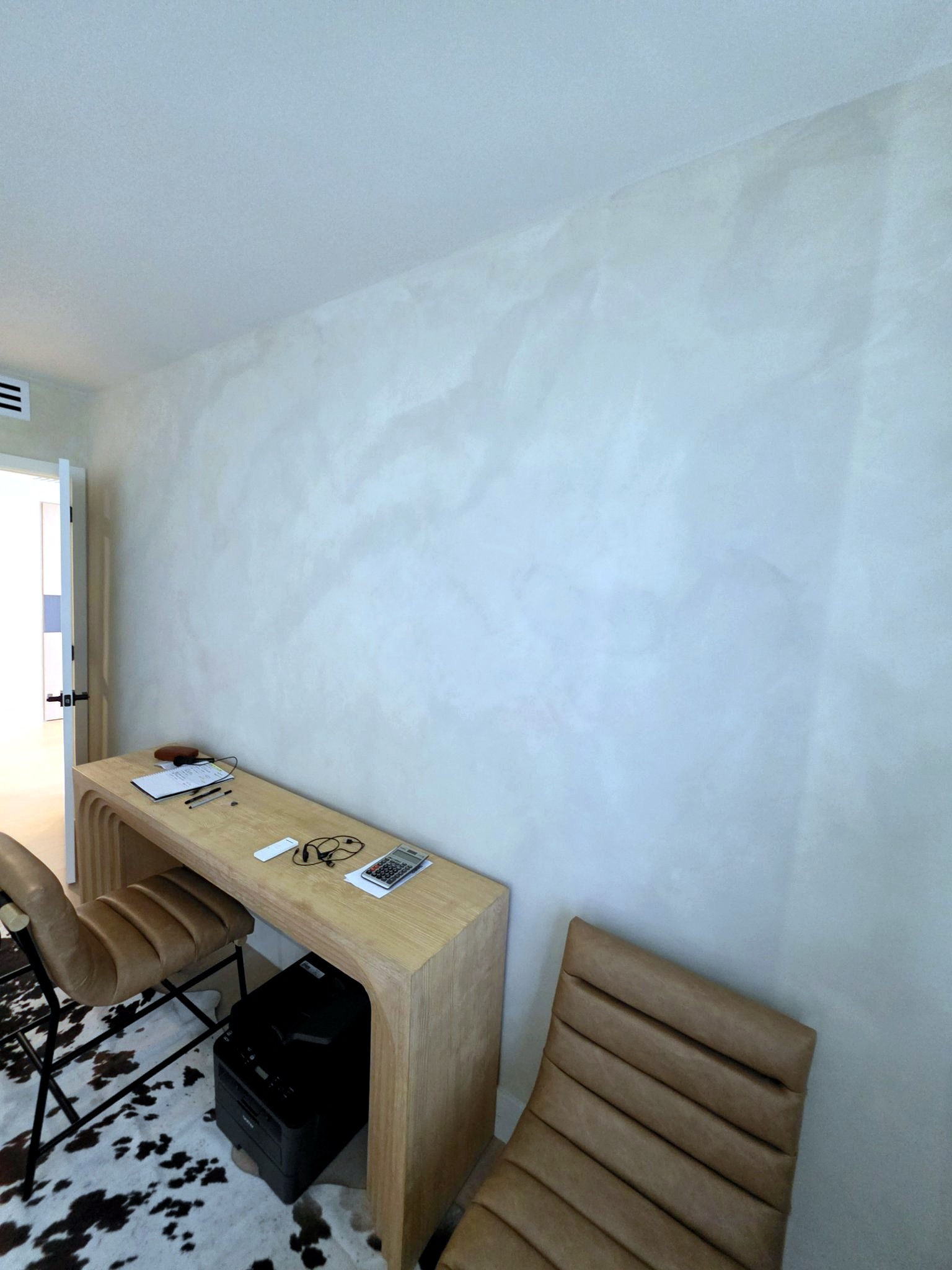 Desk corner with the tonal movement of hand-applied limewash in close view in a Bal Harbour residence