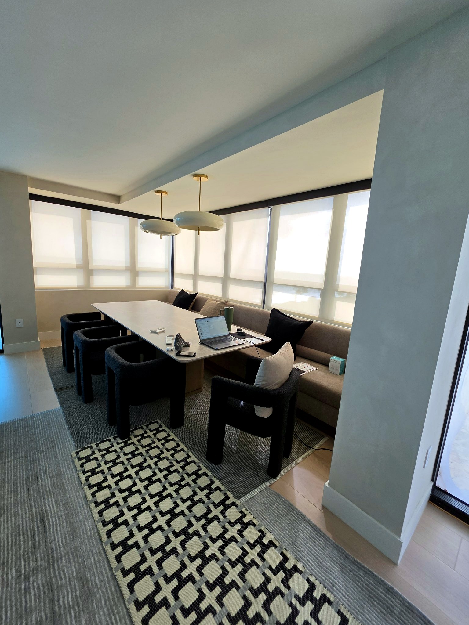Dining room beside floor-to-ceiling windows with hand-applied limewash walls in a Bal Harbour residence