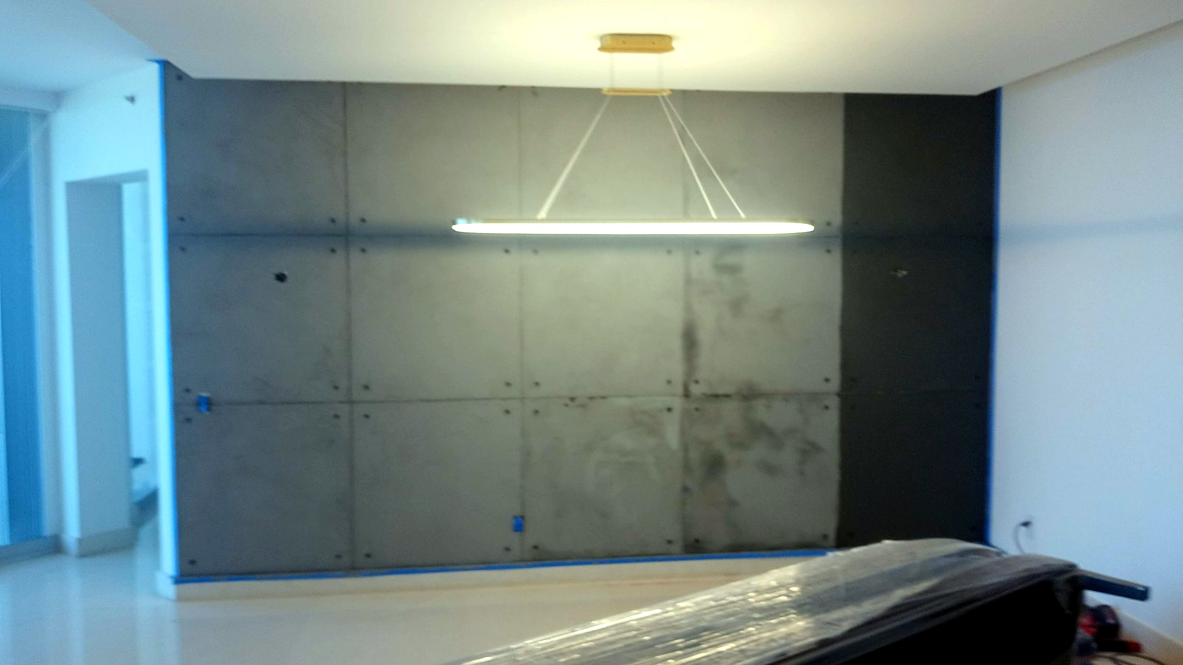 Dining room with a block-pattern microcement wall and a horizontal sculptural light