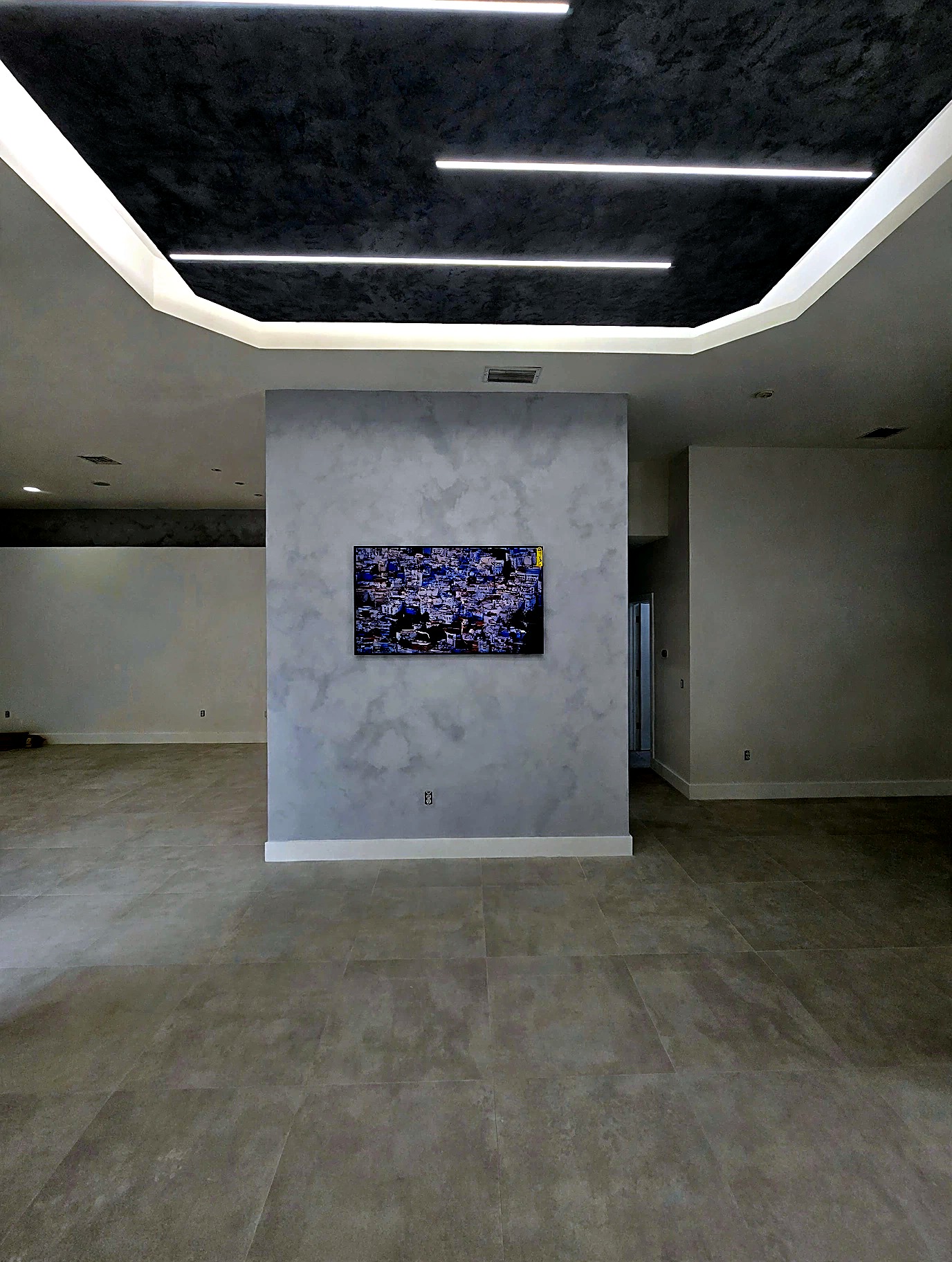 Dark travertine ceiling with linear LED lighting over a living space
