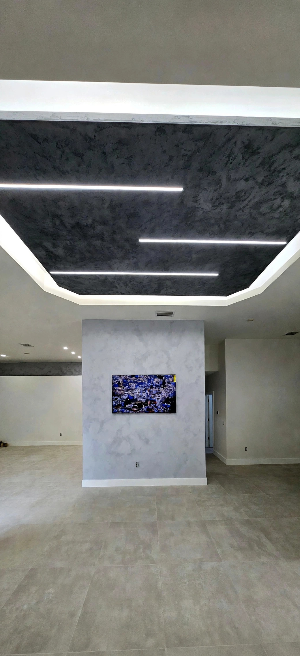 Living room with a dark travertine-finished ceiling and linear LED lighting