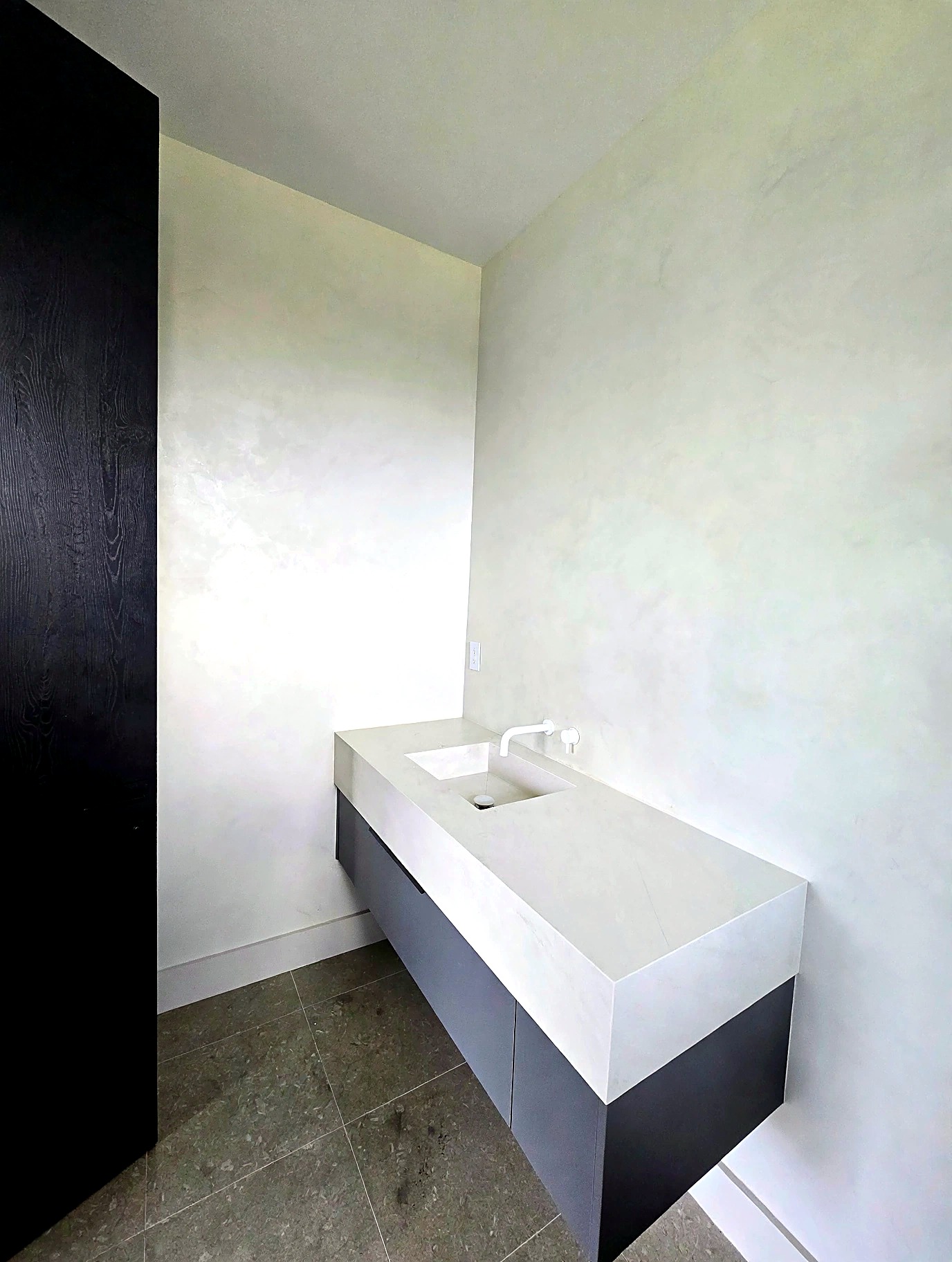 Bathroom vanity framed by hand-burnished Venetian plaster